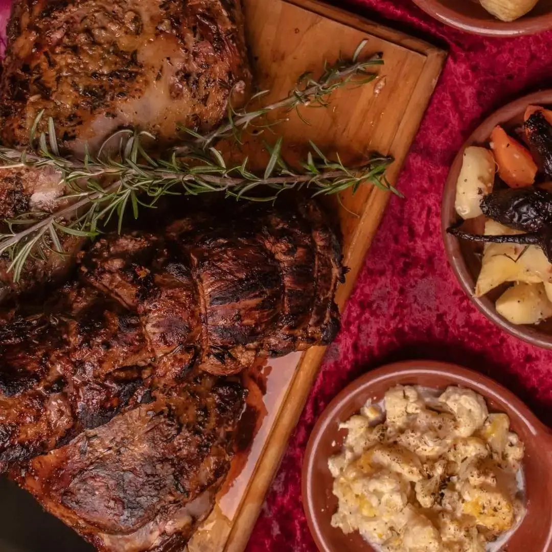 A shared roast spread with sides at The Den