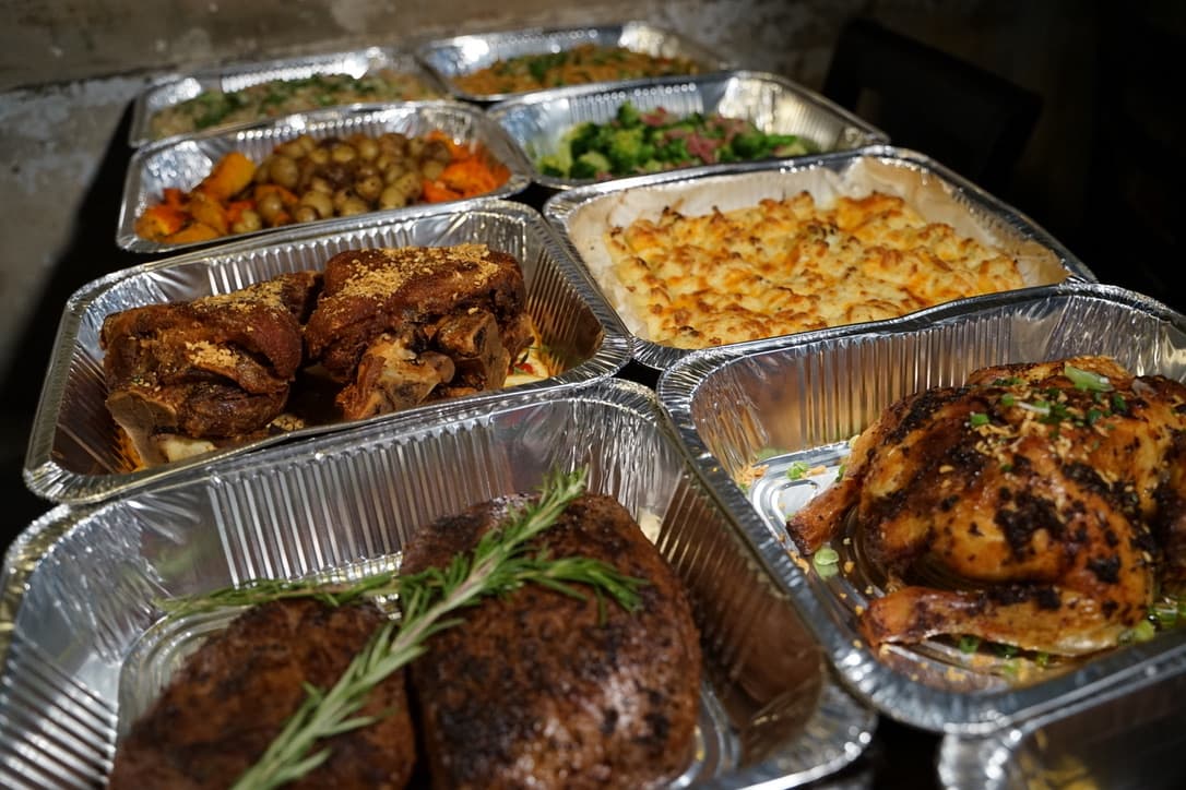 Catering trays from The Den: roast meats, cheesy potato bake and sides