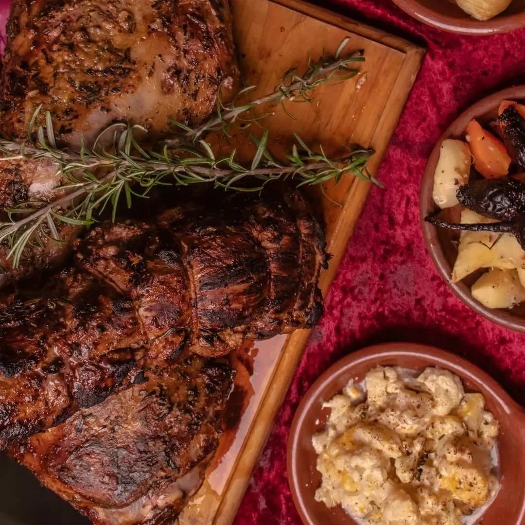 A shared roast spread with sides at The Den